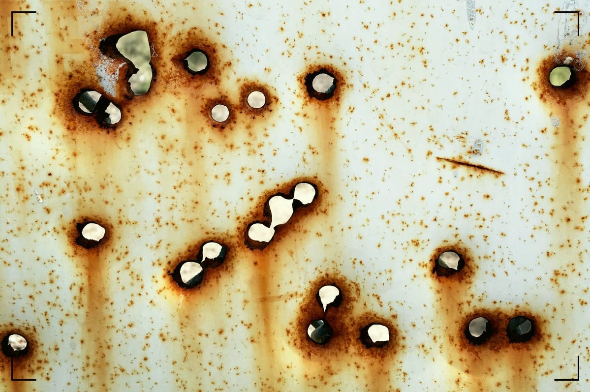 Bulletholes in a steel wall.