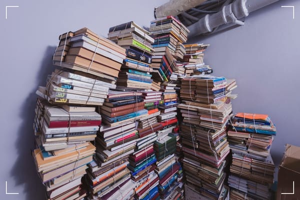 Six piles of old books, held together with thin rope.