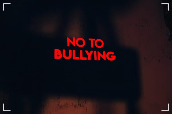 A red sign on a black background saying "no to bullying."