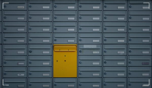 Mailboxes with a yellow one in the middle of the picture.
